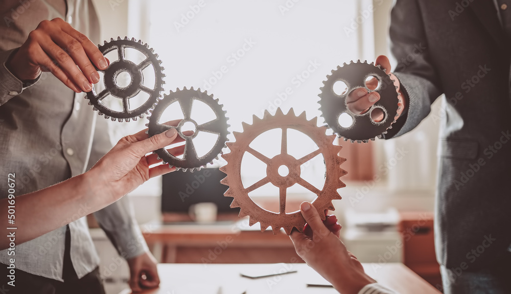 © candy1812 - Group of people working in the office while putting together cogwheels.
