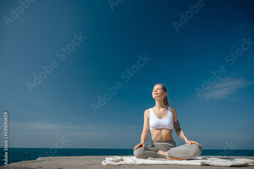 Yoga practice and meditation in nature. Woman practicing near Black sea.