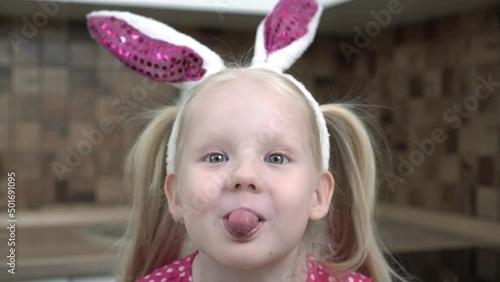child makes faces and sticks out his tongue. Child girl makes funny faces and grimaces, close-up