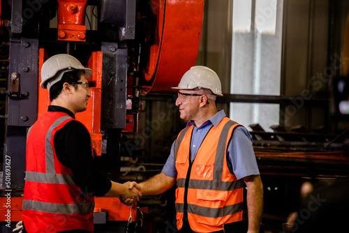 Engineers or Supervisors shake hands and discuss workshops on sheet metal forming in a manufacturing factory, Working together, Coordination and Teamwork concept.