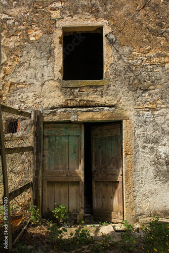 An old wooden door and window in an historic derelict farm building in the village of Karojba near Buzet in Istria, western Croatia 