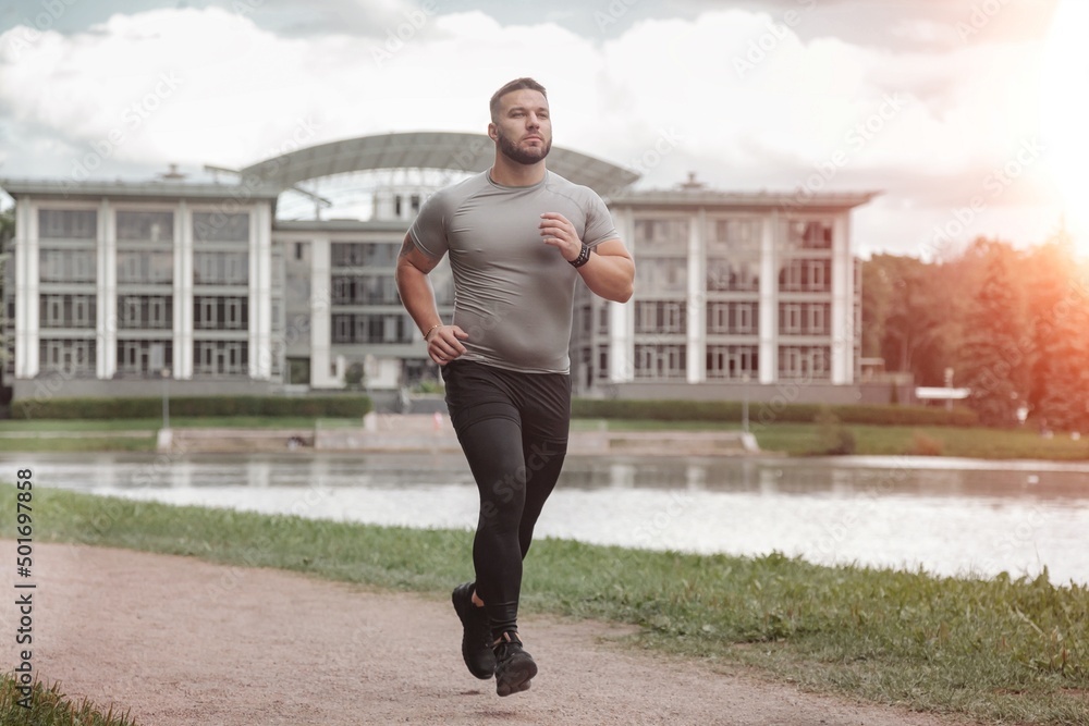 Man sportsman runner running in park training and exercising