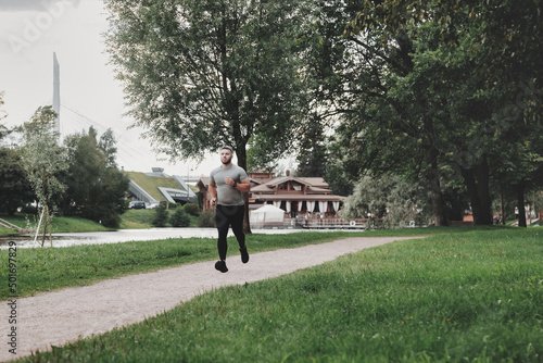 Man sportsman runner running in park training and exercising © Alex Vog
