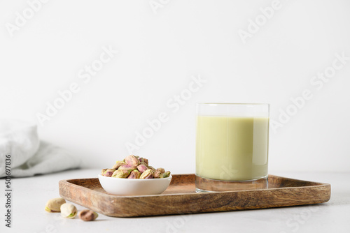 Pistachio milk and pistachios on white background. Lactose free. Vegan nutty plant based milk. Close up.