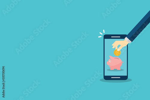 Donate, donation concept. Human hand with gold coin and piggy bank on mobile phone.