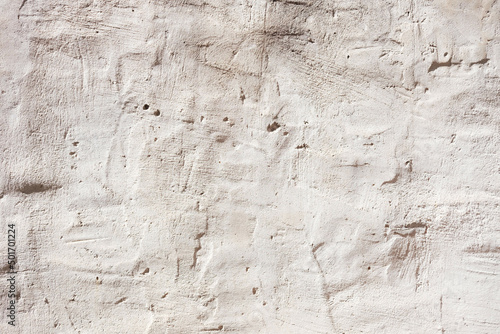 Background of a white plaster wall with imperfections in its texture.