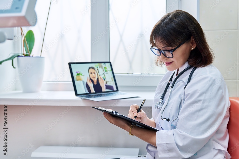 General practitioner doctor talking on videoconference with female patient General practitioner doctor talking on videoconference with female patient