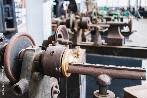 Interior of an old metalworking factory with metal lathes and presses.