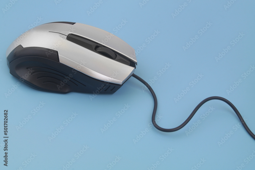 Silver computer mouse with cord on blue background Silver computer mouse with cord on blue background