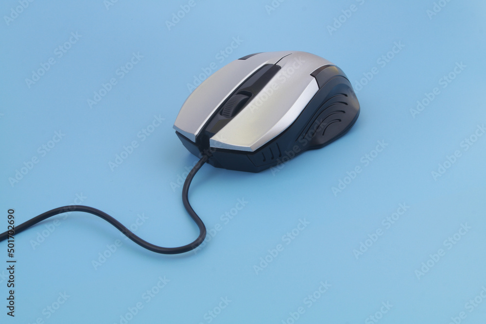 Silver computer mouse with cord on blue background Silver computer mouse with cord on blue background