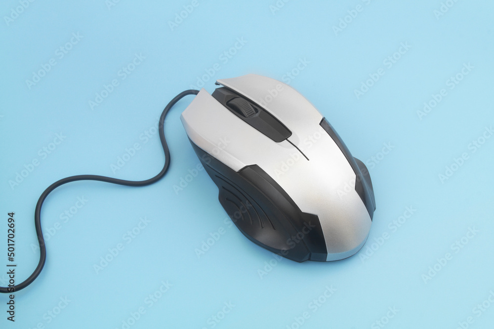 Silver computer mouse with cord on blue background Silver computer mouse with cord on blue background