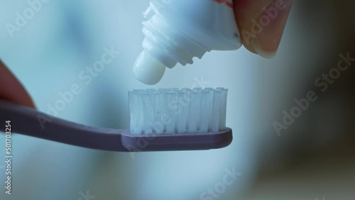Close-up of squeezing toothpaste onto a recycled plastic toothbrush