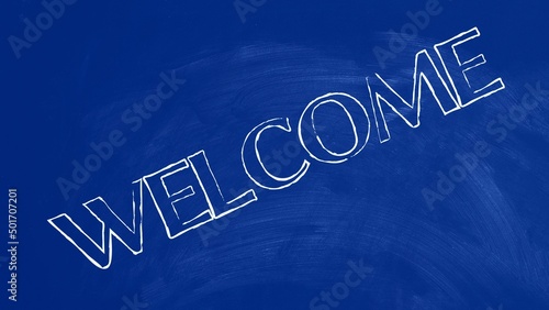 Welcome written on blue chalkboard