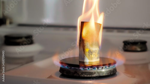 Concept of gas crisis. 50 euro bill is burning on a kitchen stove burner. European cash money. High prices of natural resources. Fire flame. Utility debt. Energy war. Saving home budget. Finance