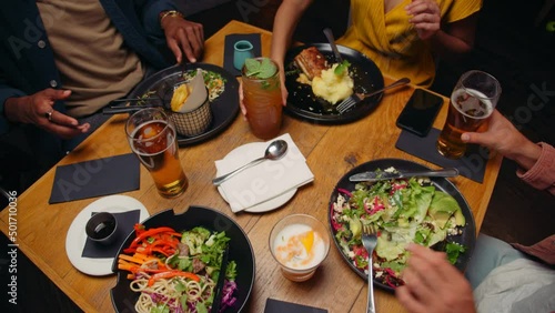 Diverse group of friends eating out at restaurant 