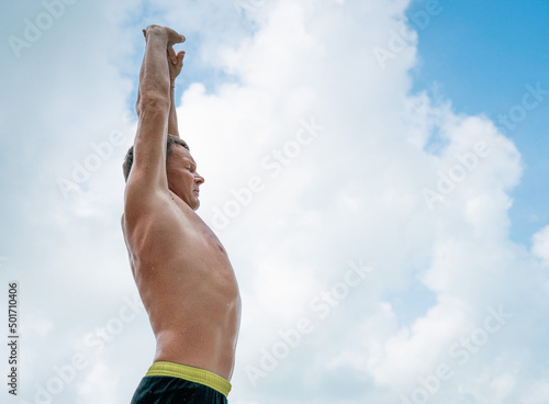 Athletic man warming up and stretching. Outdoor workout