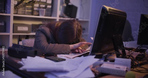 A young woman fell asleep at the table in the office, then she wakes up and stands on the phone. Slow motion 4k footage