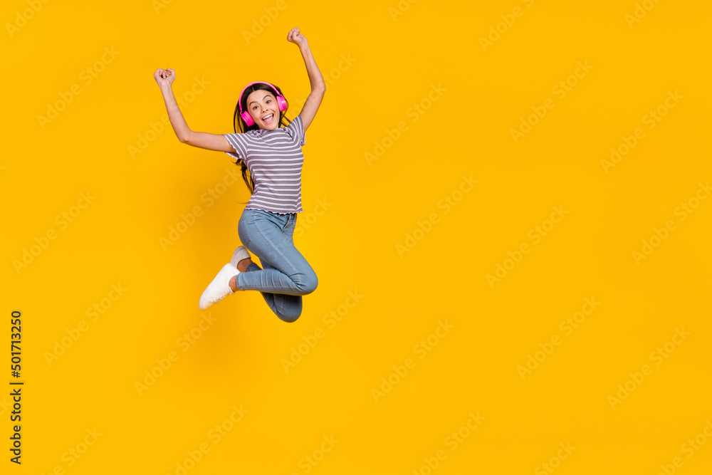 Full body photo of young excited girl have fun rejoice success fists hands melody sound isolated over yellow color background