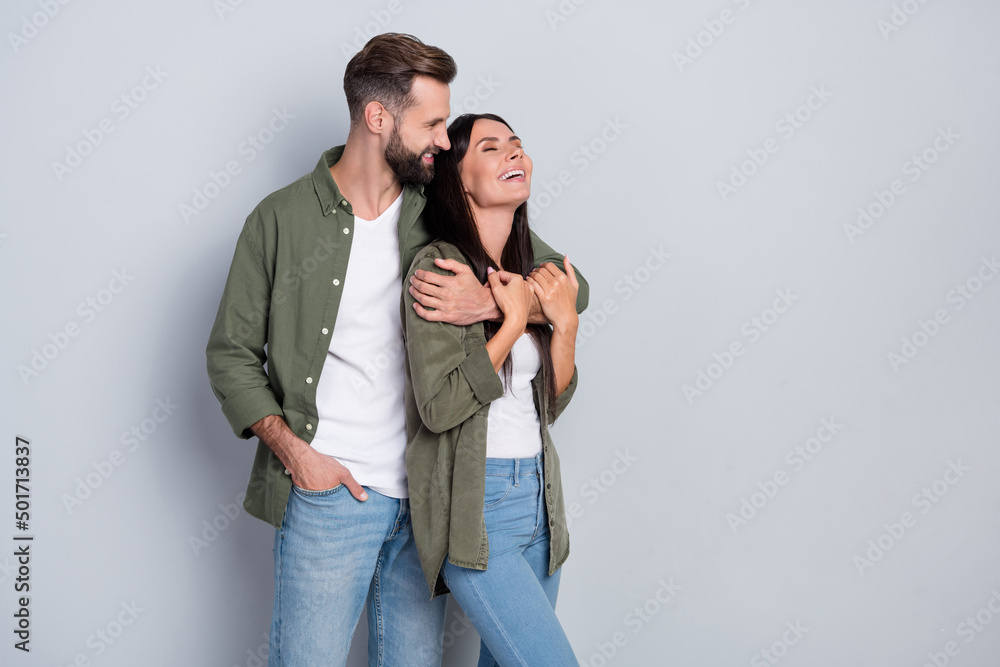Portrait of attractive tender dreamy cheerful couple hugging laughing having fun isolated over grey pastel color background Portrait of attractive tender dreamy cheerful couple hugging laughing having fun isolated over grey pastel color background