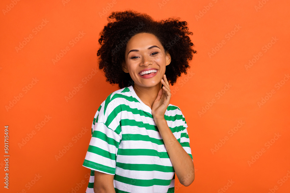 Portrait of attractive delighted cheerful wavy-haired girl touching face isolated over bright orange color background Portrait of attractive delighted cheerful wavy-haired girl touching face isolated over bright orange color background