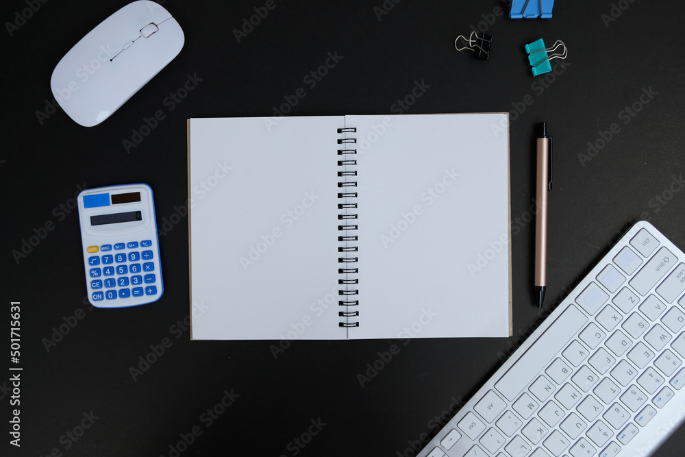 Laptop, smartphone, and supplies on a black office desk table. Computer tools on a desk table in the office, Top view with copy space, flat lay. Laptop, smartphone, and supplies on a black office desk table. Computer tools on a desk table in the office, Top view with copy space, flat lay.