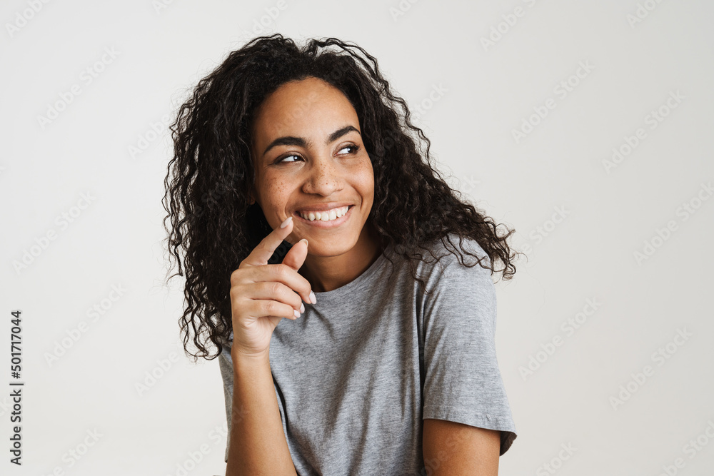 Young black woman with wavy hair laughing and looking aside Young black woman with wavy hair laughing and looking aside