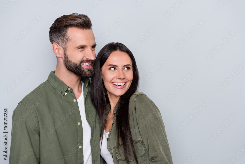 Profile side photo of young cheerful spouses romantic interested look empty space isolated over grey color background Profile side photo of young cheerful spouses romantic interested look empty space isolated over grey color background