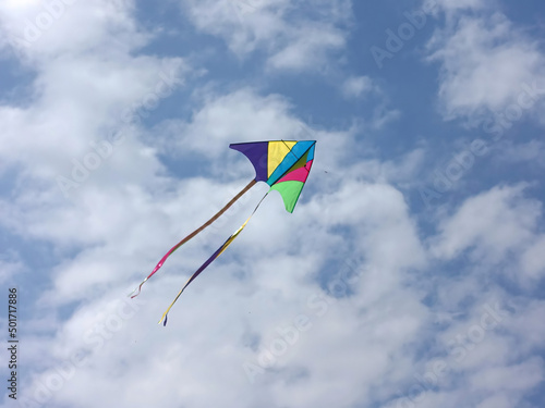Colorful kite floating on the cloudy sky