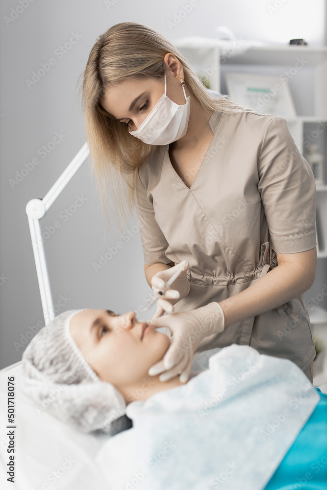 cosmetologist makes an injection in the lips of a client cosmetologist makes an injection in the lips of a client