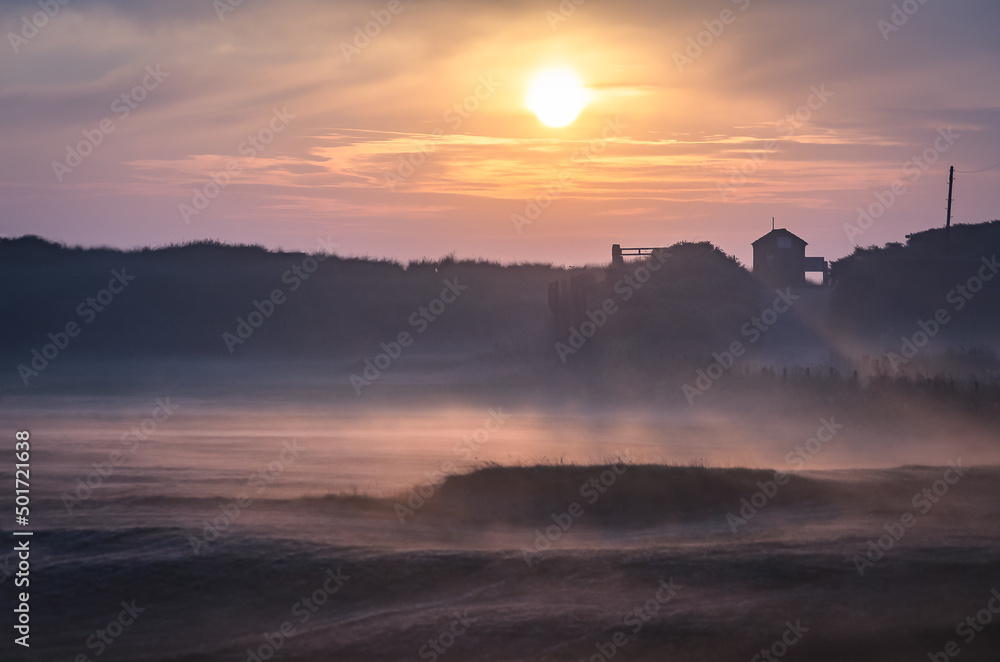 mist at sunrise  over meadow and dunes
