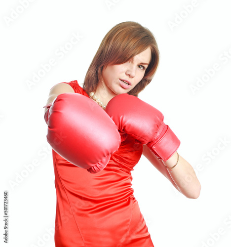 Expressive and emotional young woman in red dress and boxing gloves poses joyfully, isolate on white background, concept of beauty and power of femininity