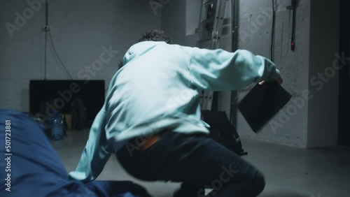 Tracking handheld shot of web developers while working in a bomb shelter during the war, hearing an explosion and a bomb attack nearby and running to the wall