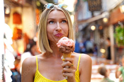 Young happy woman eating ice cream in cone while sightseeing Venice   Italy. Real people emotions. Traveler