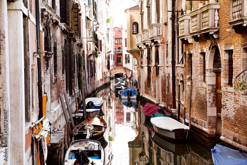 Old facades of medieval houses and canal with boats in Venice, Italy. Place to be. Tourism.