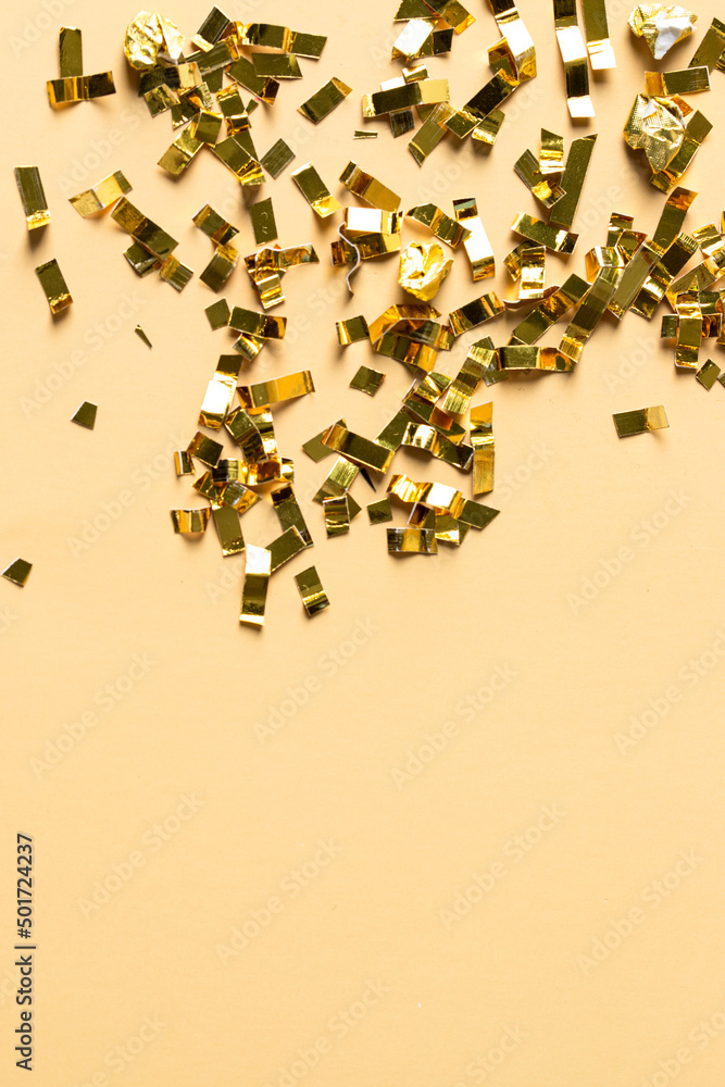 Gold sparkles particles on beige background. Holiday, wedding , cosmetic  backdrop. Copy space