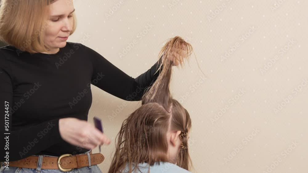 Mom combs, shares her daughter's wet hair before cutting. cutting hair