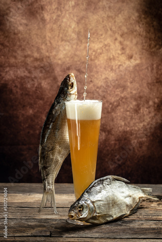 Glasses of beer and dried fish on a wooden table. Beer brewery concept. Snack for beer dried smelts. Beer background