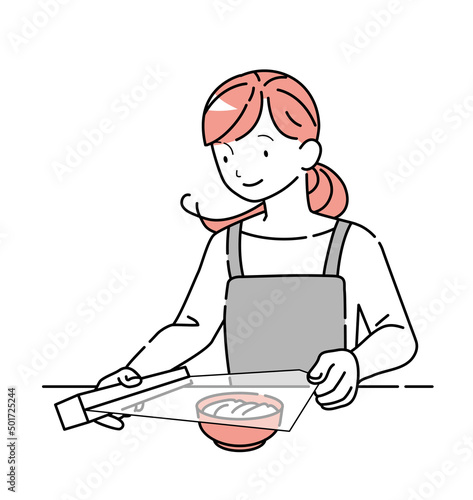 食器に食品用ラップをかける女性