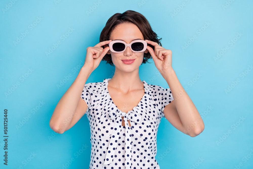 Photo of adorable satisfied person arms touch eyewear enjoy weekend isolated on blue color background Photo of adorable satisfied person arms touch eyewear enjoy weekend isolated on blue color background