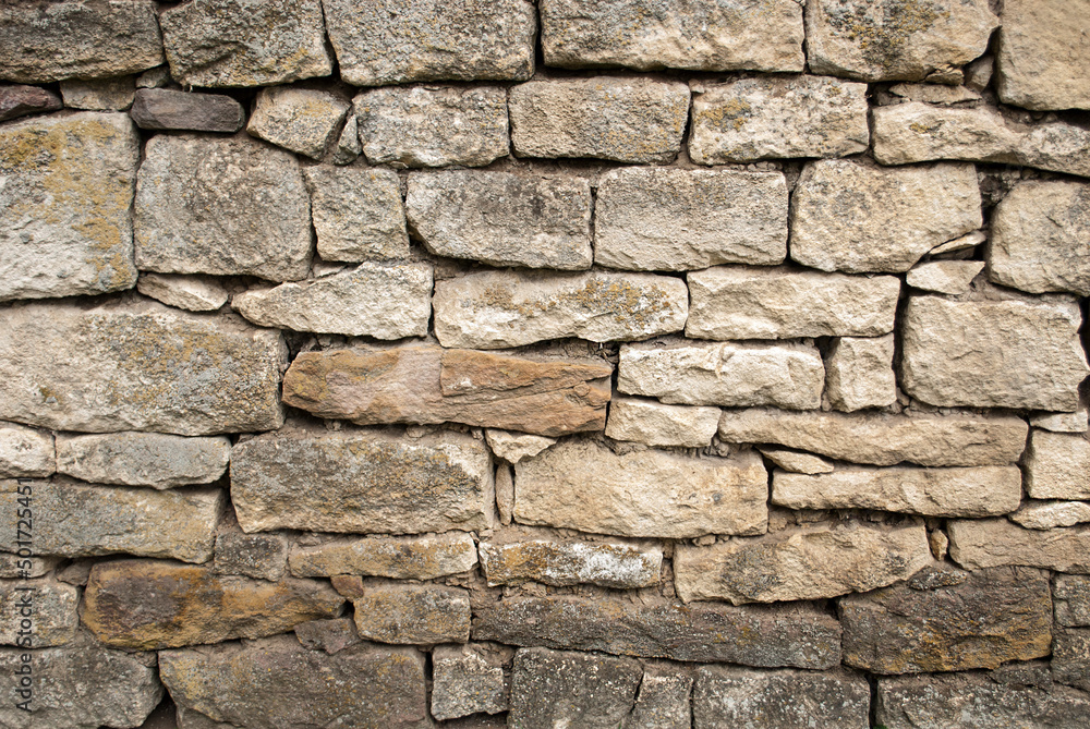 A closeup shot of an antique stone wall. Natural textured stone materials