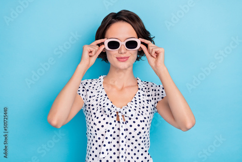 Photo of adorable satisfied person arms touch eyewear enjoy weekend isolated on blue color background