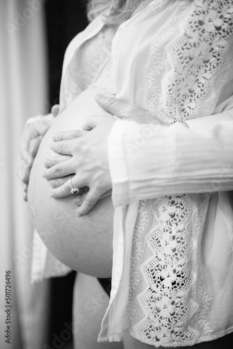 father and mother in love holding her pregnant belly black and white