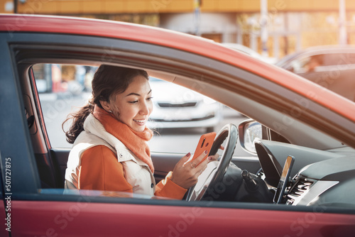 Tela A female taxi or carsharing driver looks into her smartphone app to accept a cal