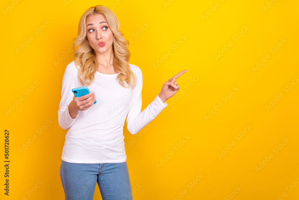 Photo of think millennial blond lady hold telephone indicate promotion wear trend cloth isolated on yellow color background Photo of think millennial blond lady hold telephone indicate promotion wear trend cloth isolated on yellow color background