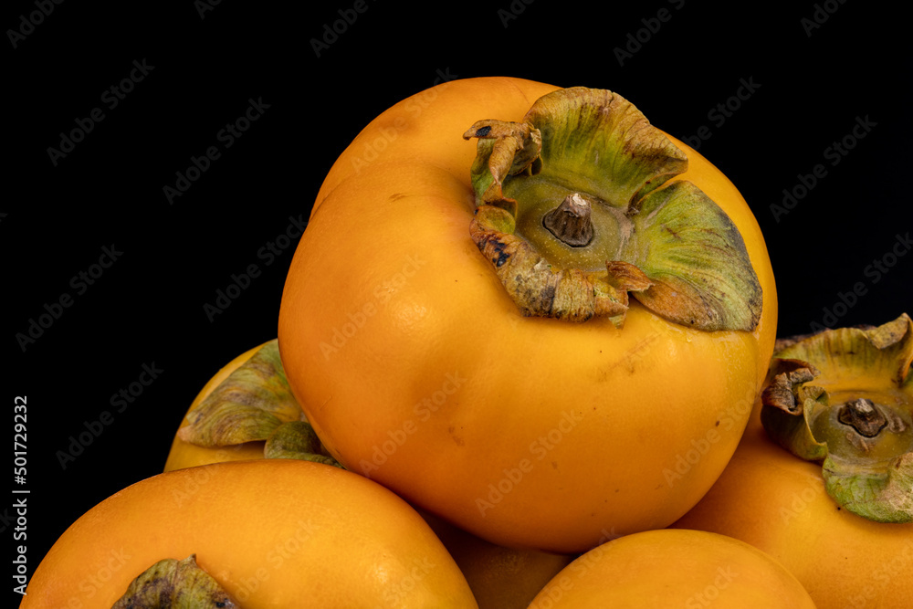 Persimmon - Fresh Kaka fruits isolated in extendable black background with shadow and water drops on it crystal clear macro details, shot using studio lights and macro lens.
