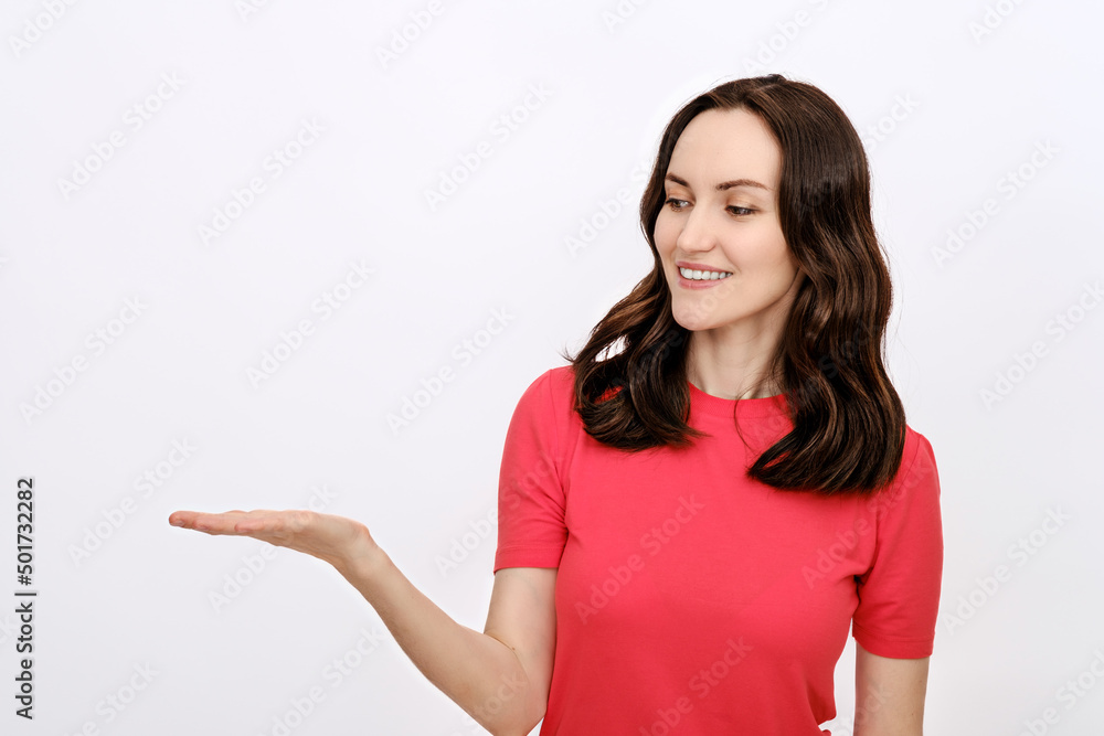 clean minimal portrait of smiling brunette woman in red T-shirt on white background holds bent arm for advertising goods, copy space, template clean minimal portrait of smiling brunette woman in red T-shirt on white background holds bent arm for advertising goods, copy space, template