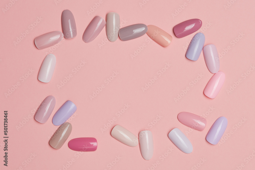 Frame of nail polish of pastel colors on pink paper or background. Testers nail polish of pastel colors on pink background. Set of false nails for manicure. Varnish color palette for nail painting. Frame of nail polish of pastel colors on pink paper or background. Testers nail polish of pastel colors on pink background. Set of false nails for manicure. Varnish color palette for nail painting.