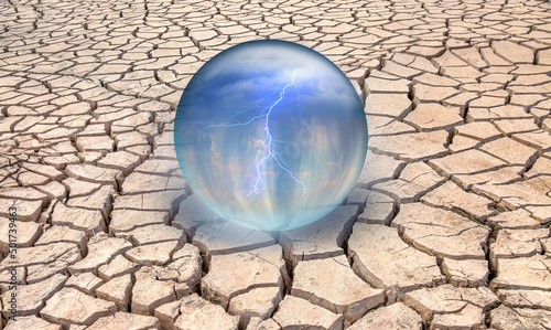 Dry soil and wasteland in the background of rain and lightning inside a glass globe