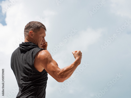 Sports man is warming up and boxing. Outdoor workout