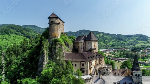 Orava castle - Oravsky Hrad in Oravsky Podzamok village in Slovakia. Medieval stronghold on extremely high and steep cliff by the Orava River. Aerial 4K panning video in summer